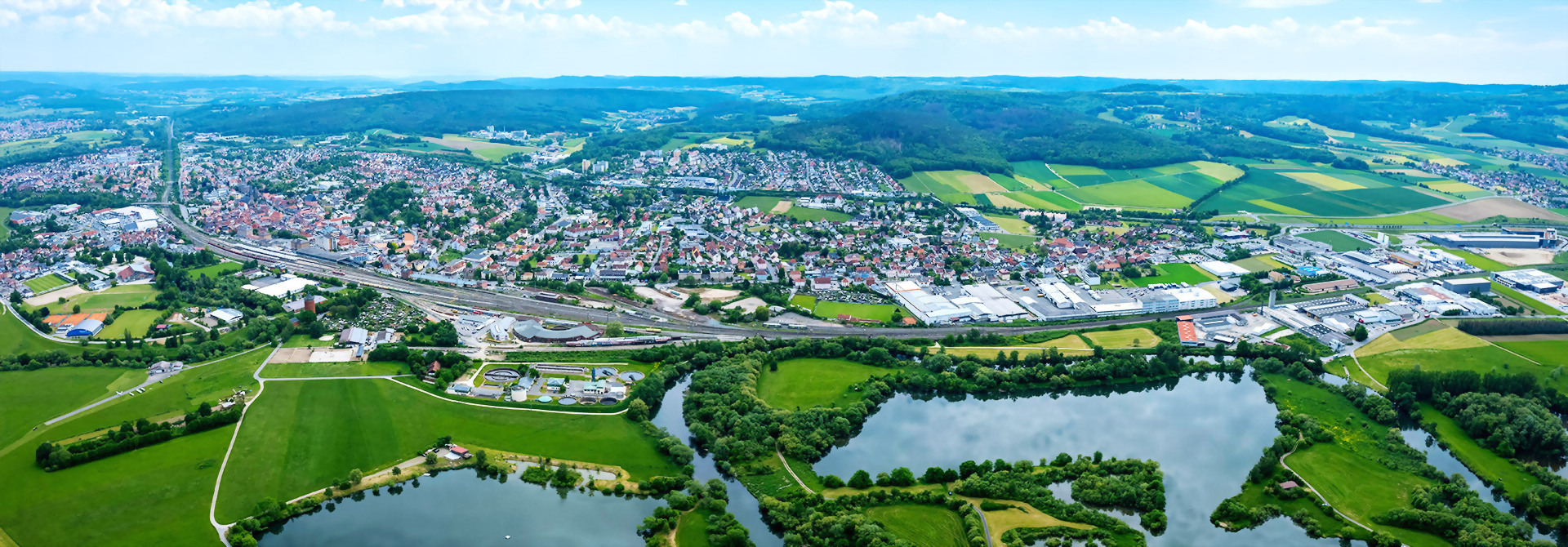Luftaufnahme der Stadt Lichtenfels in Deutschland, mit markanten Gebäuden umgeben von vielen grünen Flächen.