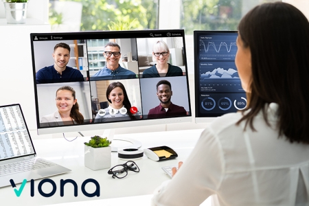 Eine Frau arbeitet an einem Schreibtisch mit zwei Monitoren und einem Computer, im Rahmen der VIONA Kolping eCademy.  