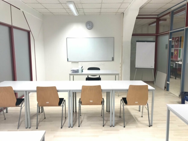 Seminarraum R 2.0 mit mehreren Tischen und Stühlen, ideal für Gruppenaktivitäten oder Präsentationen.
